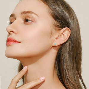 Boucles d'oreilles puces en argent S925 et opale portées par un mannequin style de luxe