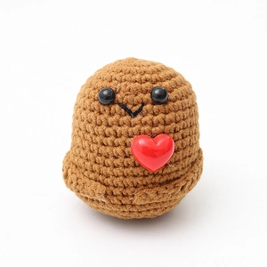 Macro detail of hand-knitted brown potato doll with a small red heart and soft wool texture