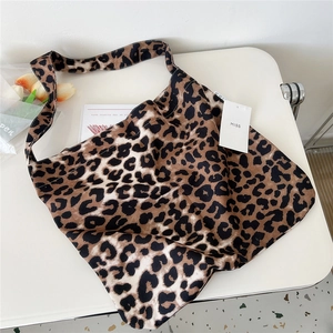 Detailed close-up of brown leopard print canvas tote bag with books and MISS hangtag