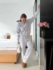 Women's grey two-piece tracksuit featuring a hooded sweatshirt and drawstring joggers
