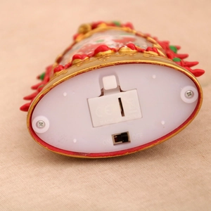 Close-up of base showing battery compartment and power switch for Christmas tree oil lamp