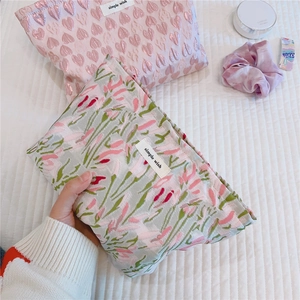 Detailed view of jacquard floral makeup bag with simple wish label and pink heart pattern