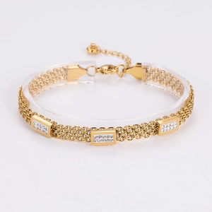 Detail of layered gold bracelet with sparkling cubic zirconia inlaid rectangular charms