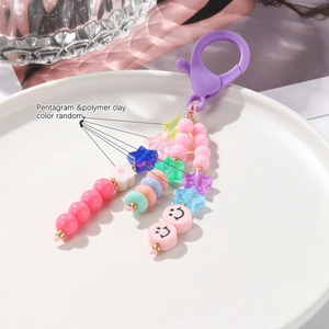 Détail du porte-clés à perles colorées avec smiley et étoiles sur plateau céramique