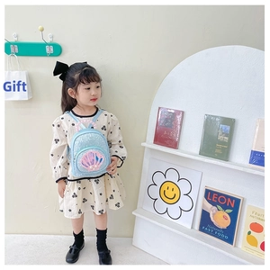 Detailed view of blue sequin backpack with pearl handle on a young girl model