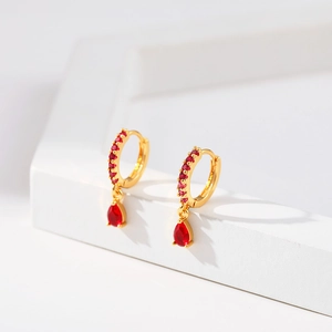 Macro detail of 18K gold plated teardrop earrings with red crystals and micro zircons
