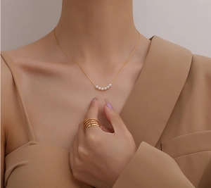 Minimalistische 18K vergoldete Perlenkette mit mehrlagigem Spiralring am Modell