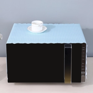 Close-up of light blue polka dot microwave dust cover with elegant scalloped lace edges