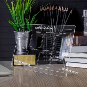 Detailed view of a clear acrylic weekly planner board on a desk with metal stands