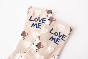 Detailed close-up of beige cotton crew socks with cat pattern and LOVE ME text design