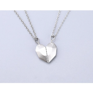 Detail showing two-piece magnetic heart pendant with geometric facets in silver finish
