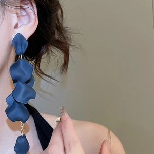 Detailed view of long navy acrylic petal tassel earrings on a model showing dangle effect