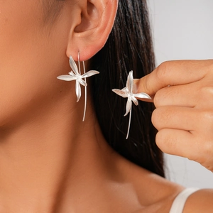 Elegant silver iris flower dangle earrings with long tassel on model left ear