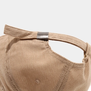 Detail of khaki corduroy baseball cap with an adjustable bronze metal buckle strap