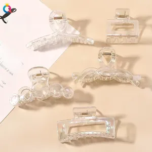 Close-up of five clear acrylic hair claws with iridescent aurora finish and geometric shapes