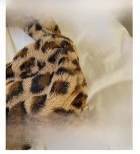 Close-up of leopard print faux fur material with dense texture and glossy finish