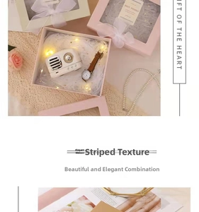 Detail of pink and white gift box with window lid, organza ribbon and LED light string