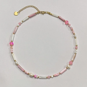 Detail of pink and cream freshwater shell beads with a golden heart pendant necklace