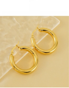 Macro detail of high-polish 18K gold-plated titanium steel thick hoop earrings