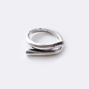 Close-up of silver open ring with twisted design and vintage textured metal surface
