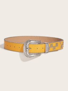 Detail of yellow crocodile pattern leather belt with rhinestone buckle and metal studs