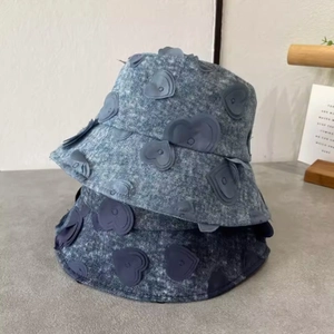 Detail of overlapping heart patches on light and dark blue denim bucket hats