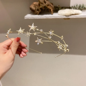 Detail of gold star headband featuring rhinestones and pearls on multi-layer frame