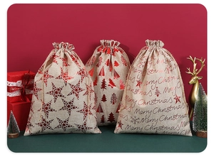Detail of burlap Christmas drawstring bag with red tree print and festive decor