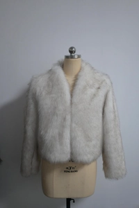 Détails de la texture épaisse et de la fausse fourrure blanche de cette veste courte