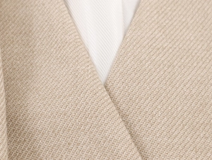 Detailed macro view of the scarf collar lapel and fine twill fabric on the beige blazer