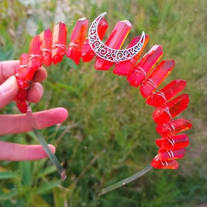 Detailed shot of red crystal wizard crown with silver hollow moon on grass background