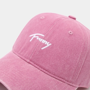 Close-up of pink washed cotton baseball cap with white 'Funny' letter embroidery detail