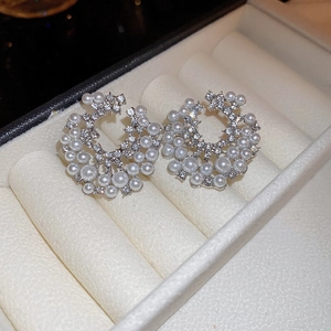 Vue macro de boucles d'oreilles circulaires avec perles et strass dans un coffret