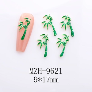Macro view of 9x17mm green bamboo leaf nail charms with gold edges on white background
