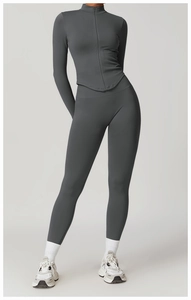 Détail de la veste de yoga gris foncé à col montant et des leggings de sport à taille haute