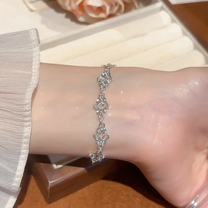 Detailed close-up of a silver hollow heart bracelet on a wrist with soft lighting