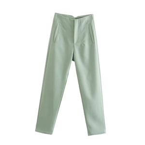Dettaglio ravvicinato dei pantaloni slim verde chiaro a vita alta con pieghe decorative