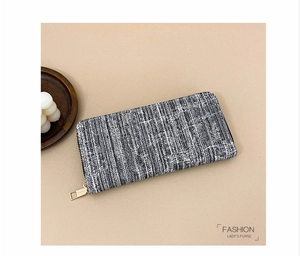 Detailed close-up of textured fabric texture and golden zipper on long wallet