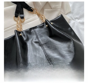 Détails de la couture matelassée et de la chaîne dorée sur ce sac cabas noir