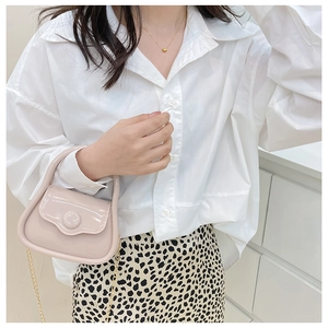 Pink jelly mini bag with gold chain strap styled on a white shirt and leopard skirt