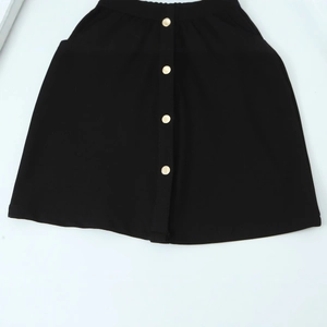 Jupe trapèze noire minimaliste avec quatre boutons décoratifs en métal doré sur fond blanc