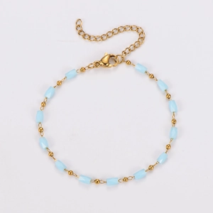 Macro view of golden stainless steel chain with light blue faceted beads and lobster clasp