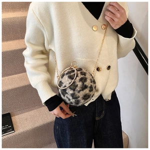 Detailed view of women's leopard print plush sphere bag with gold chain and ring handle