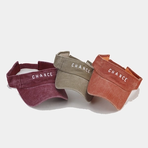 Detail of washed cotton sun visors with CHANCE embroidery in burgundy, khaki and orange