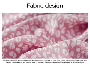 Detail view of pink and white leopard print fabric with fabric care washing instructions