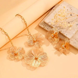Detailed view of golden filigree flower jewelry set on aesthetic warm background