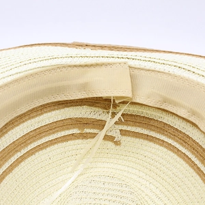 Detailed macro view of the inner woven straw texture with adjustable strap on sun hat