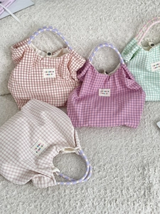 Borse tote a quadretti in quattro colori con manici in corda su tappeto di peluche