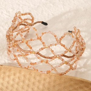 Detail of handmade champagne crystal beaded bridal headband with intricate hollow woven texture