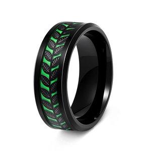 Detail of matte black ring with emerald green background and leaf texture inlay
